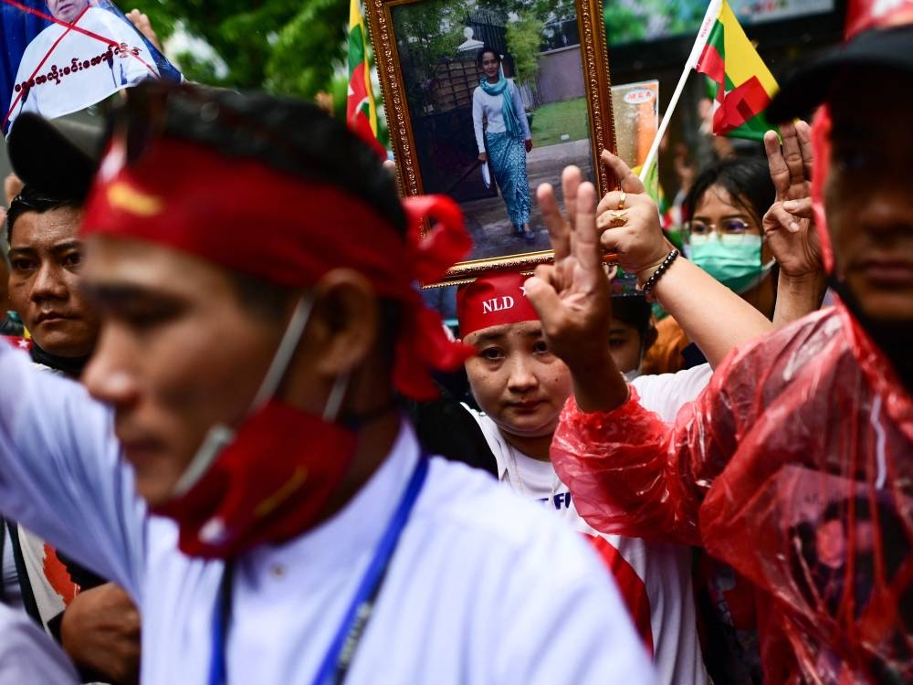 Protesters show the three finger salute and hold photos of detained Myanmar civilian leader Aung San Suu Kyi during a demonstration against the Myanmar military junta’ execution of four prisoners, outside the Myanmar Embassy in Bangkok  July 26, 2022. — AFP pic