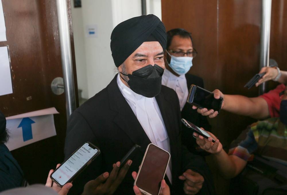 Lawyers Datuk Rajpal Singh (centre) and Salim Bashir speaking to the press at the Ipoh courthouse in this February 15, 2022 file picture. — Picture by Farhan Najib