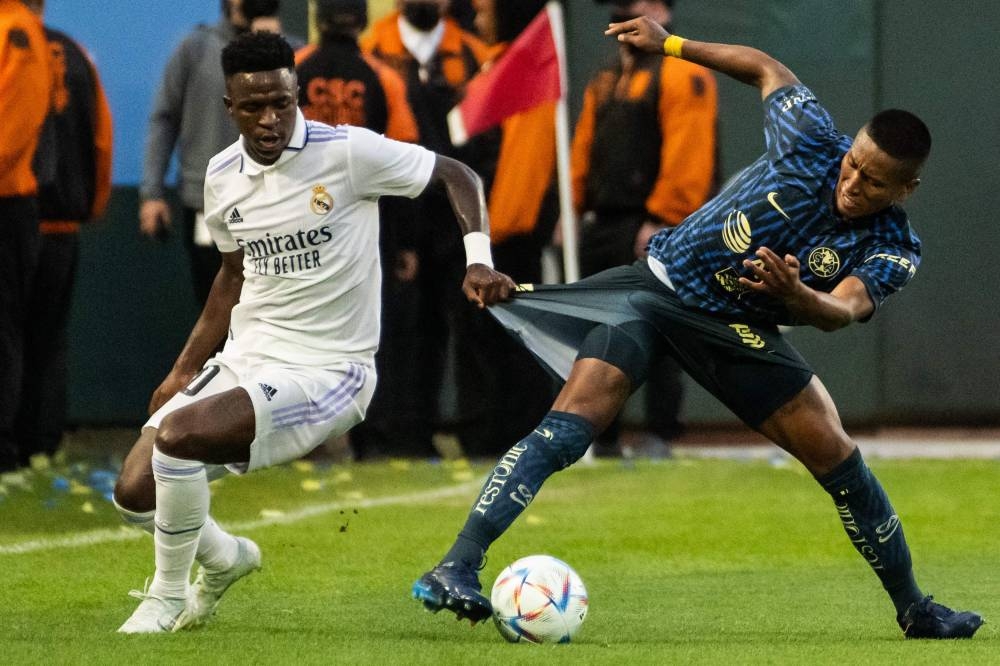 Real Madrid's Brazilian forward Vinicius grabs the shorts of Club America's Peruvian midfielder Pedro Aquino Sanchez at the Oracle Park stadium in San Francisco July 26, 2022. — AFP pic