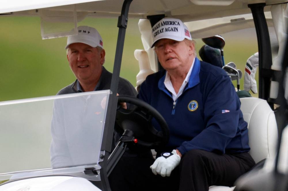 Donald Trump drives a golf cart at the Trump National Golf Club in Sterling, Virginia November 22, 2020. — Reuters pic 