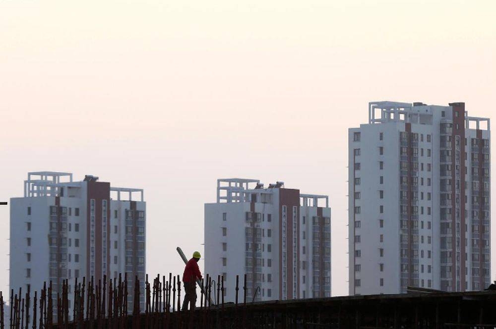 A worker stands on the scaffolding at a construction site against a backdrop of residential buildings in Huaian, Jiangsu province October 18, 2018. — Reuters pic