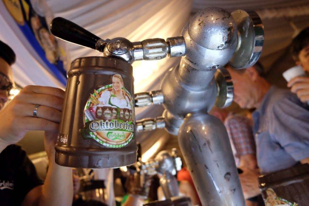 A bartender pours a mug of beer during Oktoberfest celebrations in George Town, October 13, 2017. — Picture by KE Ooi