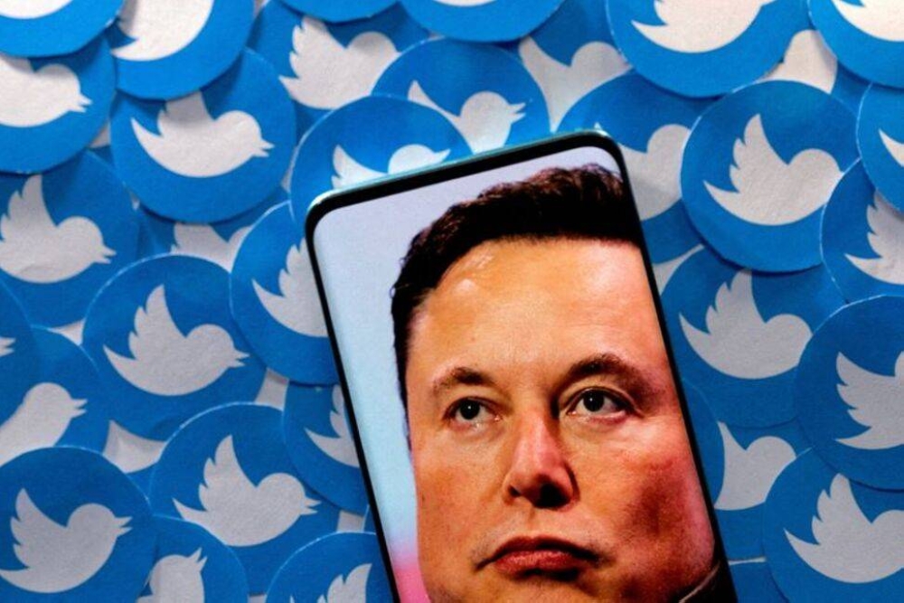 An image of Elon Musk is seen on smartphone placed on printed Twitter logos in this picture illustration taken April 28, 2022. — Reuters pic