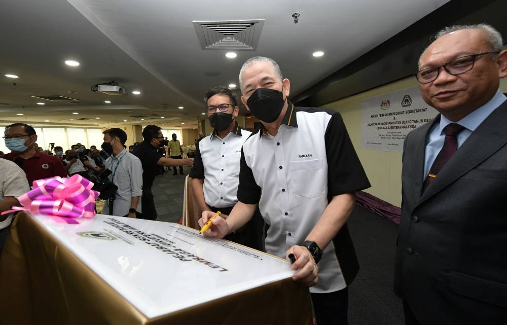 Senior Minister of Public Works Datuk Seri Fadillah Yusof signing the inauguration plaque of the Malaysian Engineers Board (LJM) Sarawak State Branch Secretariat Office at the JKR Kuching Auditorium in Kuching, July 30, 2022. — Bernama pic