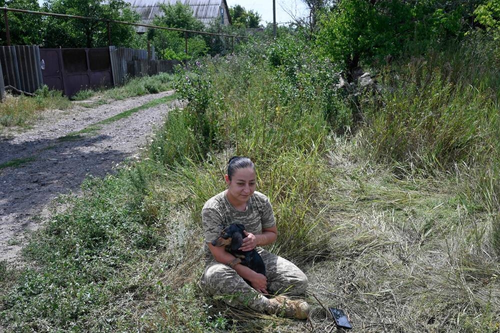 Karina, a former textile worker of Tajik origin, stands next to a military vehicle during an interview with AFP in Donbas region, eastern Ukraine, on July 26, 2022. — AFP pic