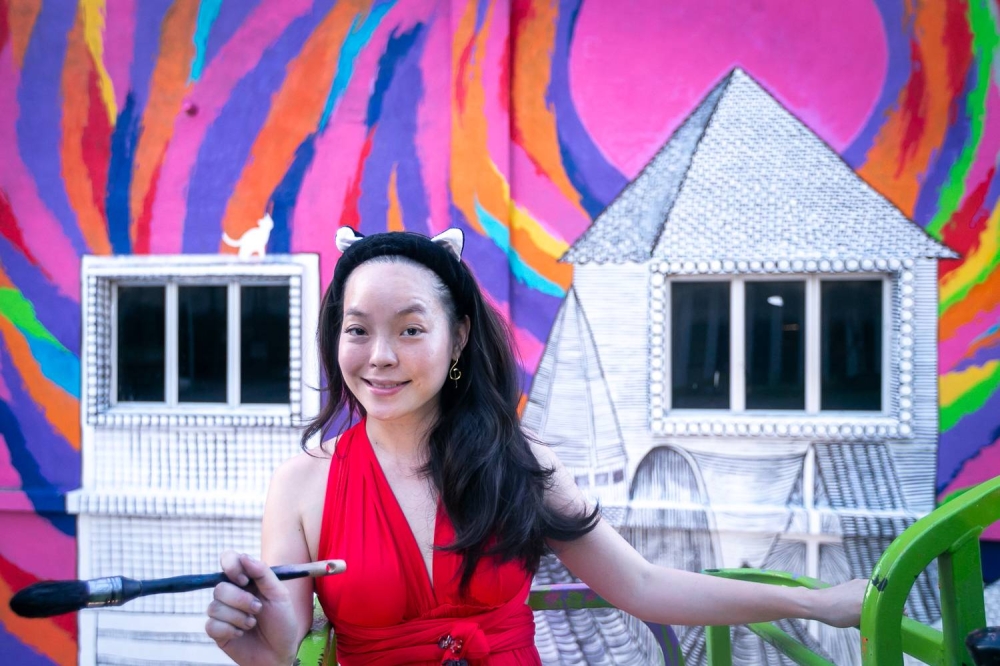 Contemporary artist Poesy Liang in the midst of completing the Rooftop Cat mural. — Picture by Devan Manuel