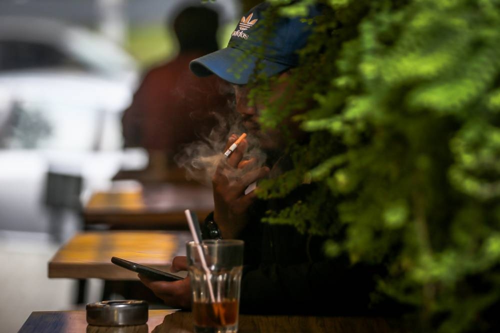 A man is seen smoking in a restaurant in Bangsar in this file picture taken on October 9, 2018. — Picture by Hari Anggara