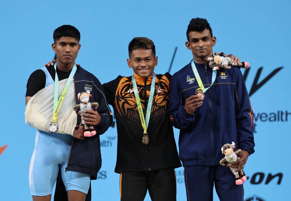 Mohamad Aniq Kasdan(centre) is seen with Indian silver medalist Sangket Mahadev(left) and the Sri Lankan bronze medalist D.I.K Yodage(right). — Bernama pic