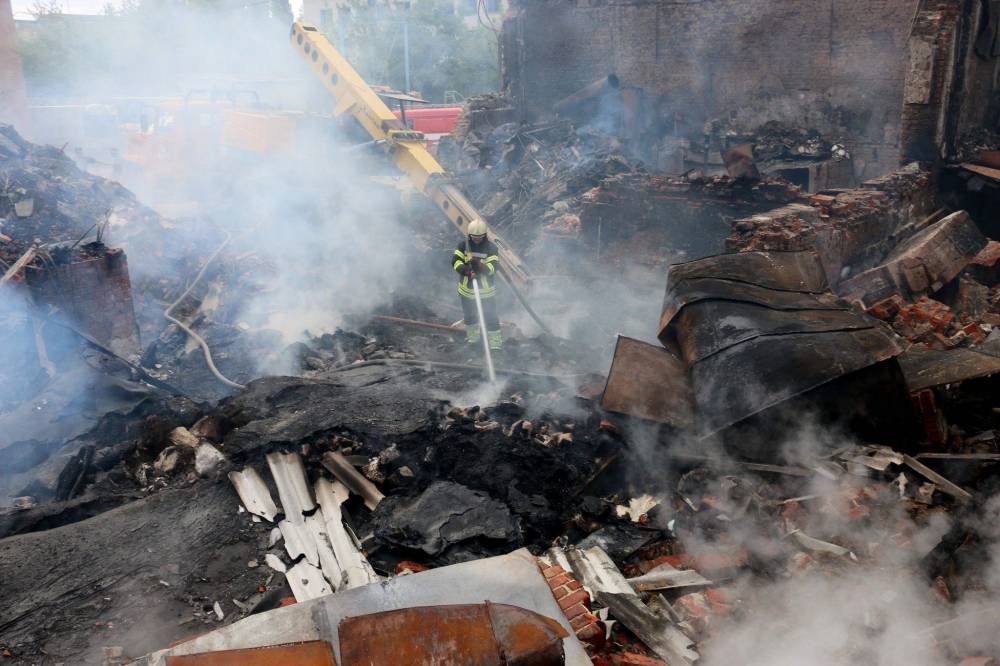 This handout picture taken and released by Ukrainian Emergency Service on July 31, 2022 shows a firefighter pushing out a fire in a building after shelling in Kharkiv, amid the Russian invasion of Ukraine. — Ukrainian Emergency Service / AFP pic