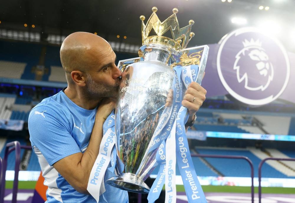 Manchester City manager Pep Guardiola celebrates with the trophy after winning the Premier League at the Etihad Stadium, Manchester May 22, 2022. — Reuters pic