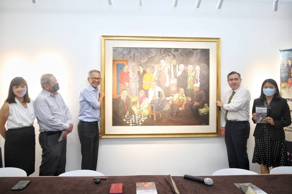 Tony Pua hands over his painting to Anthony Loke during a press conference for the launch of DAP’s GE15 fundraiser ‘Langkah Sheraton NFTs’ at Theatre Impian, Plaza Bukit Jalil August 1, 2022. — Picture by Choo Choy May