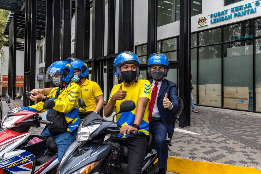 Lembah Pantai MP Fahmi Fadzil takes a ride on a Dego Ride moped in Lembah Pantai, Kuala Lumpur, August 2, 2022. — Picture by Firdaus Latif