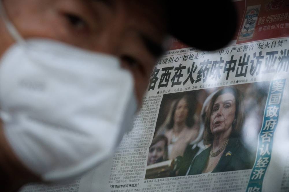 A man stands in front of a glass cabinet displaying the Global Times newspaper that features a front page article about US House of Representatives Speaker Nancy Pelosi's Asia tour in Beijing, China, August 1, 2022. — Reuters pic