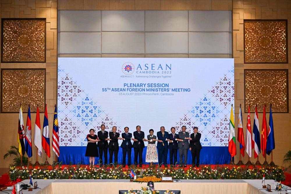 Asean foreign ministers and Asean secretary-general Lim Jock Hoi shake hands as they pose for a family photo during a plenary session as part of the 55th Asean Foreign Ministers Meeting in Phnom Penh, August 3, 2022. — AFP pic 