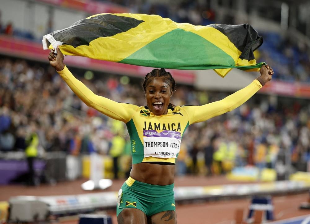 Jamaica's Elaine Thompson-Herah celebrates after winning gold at the Women's 100m event in Birmingham August 3, 2022. — Reuters pic