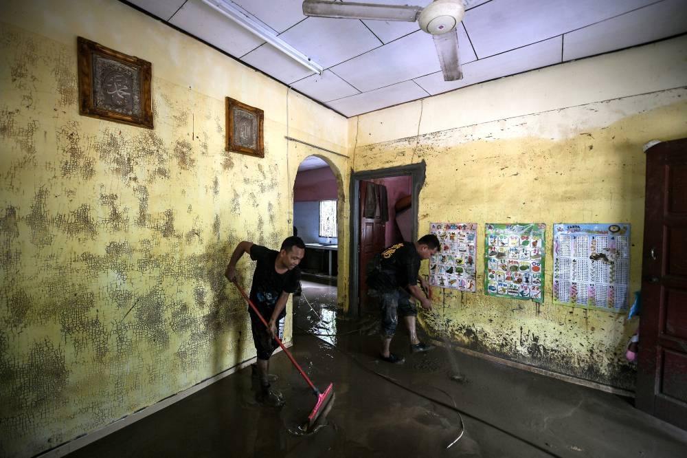 People are seen cleaning up at Kampung Teluk Sanau after floodwaters recede in Baling August 3, 2022. ― Bernama pic
