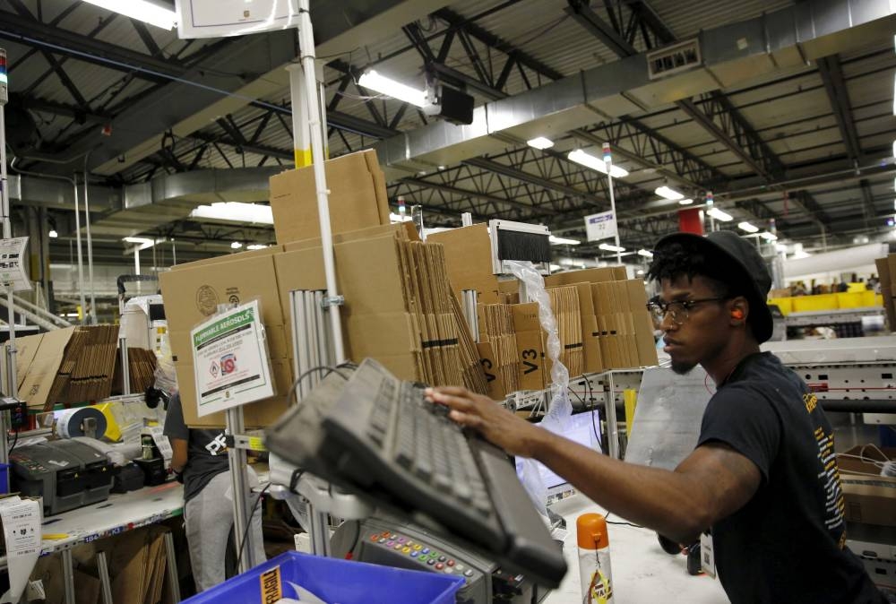 A worker prepares packaged products for shipment at an Amazon Fulfilment Center in Tracy, California, August 3, 2015. — Reuters pic