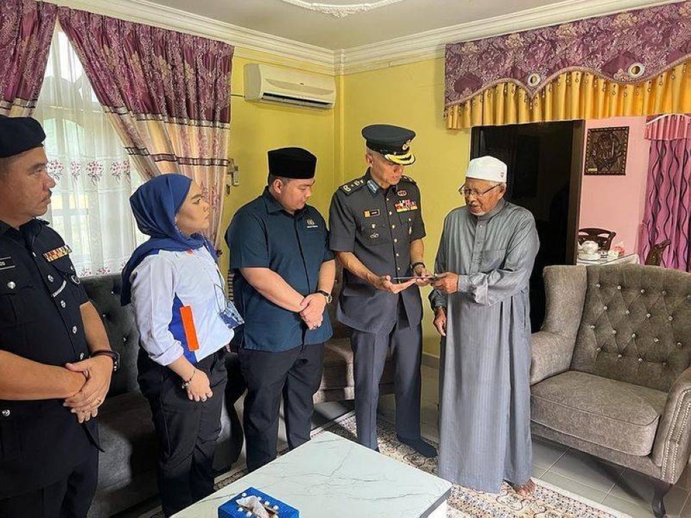 Brigadier General Datuk Mohamad Zahari Yahya (second from right) hands contributions from the King to Sekolah Menengah Agama (Arab) Yayasan Al-Kahriah principal Abdul Rahman Yahya. — Picture via Facebook