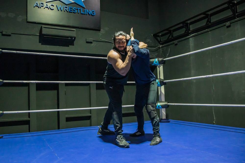 Shaukat and the world's first Hijab-wearing pro-wrestler, Nor 'Phoenix' Diana, during a training session at Apac Wrestling. — Picture by Firdaus Latif