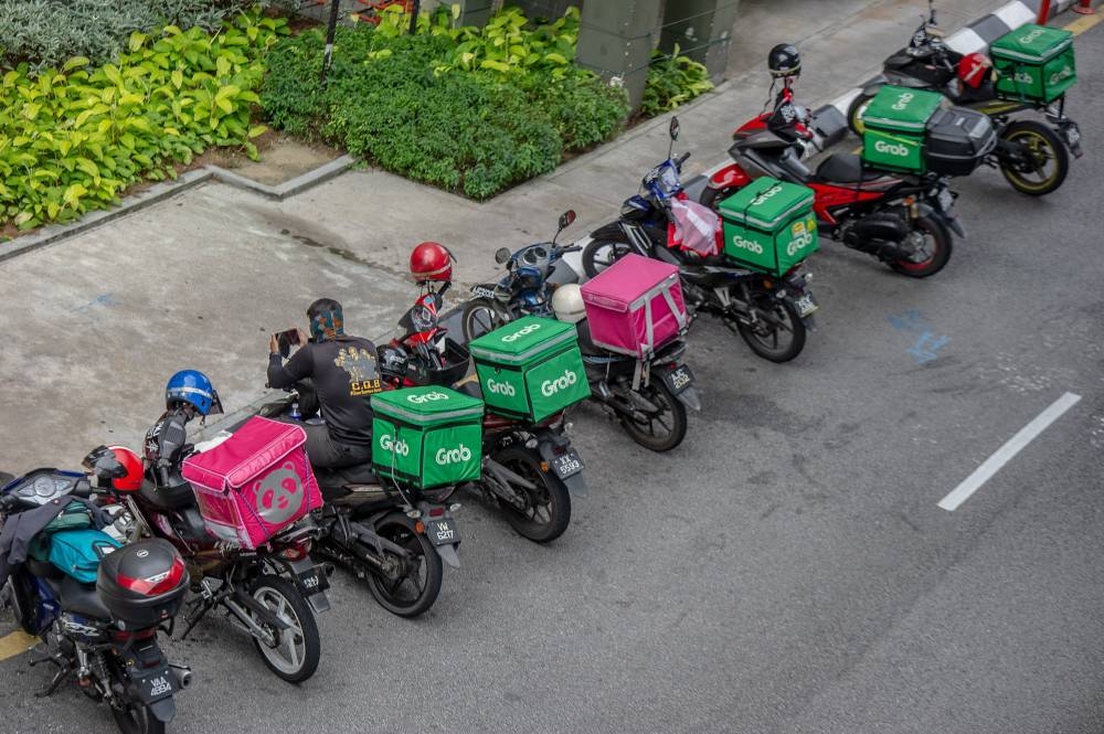 Food delivery riders wait to pick up their orders at Sunway Putra mall, Kuala Lumpur January 14, 2021. — Picture by Shafwan Zaidon