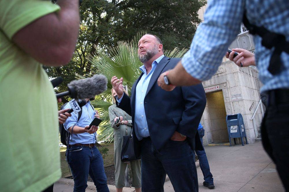 Alex Jones steps outside of the Travis County Courthouse, to do interviews with media after he was questioned under oath about text messages and emails by lawyer Mark Bankston, in Austin, Texas, US, August 3, 2022. — Briana Sanchez/Pool via Reuters