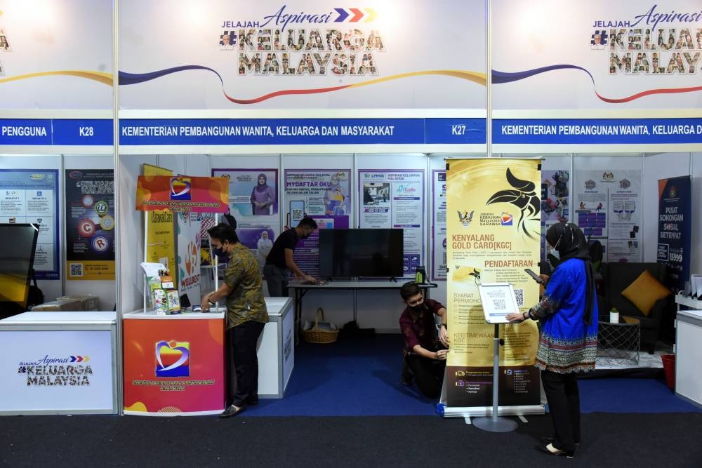 Staff members decorate the exhibition space for the Sarawak Keluarga Malaysia Aspirations (AKM) tour at Petra Jaya Square, Kuching August 4, 2022. — Bernama pic