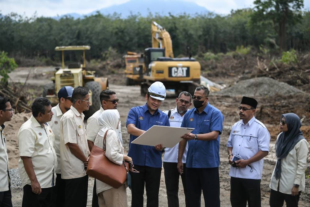 Senior Minister of Education Datuk Dr Mohd Radzi Jidin (fifth right) discussing with Public Works Department (JKR) staff when visiting the school construction project site in conjunction with the Sekolah Menengah Kebangsaan Bohor Jaya ground breaking ceremony in Langkawi, August 7, 2022. — Bernama pic