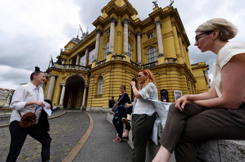 Danijela Matijevic (2nd left) gives explanations in front of the Mestrovic Pavilion, the former Museum of the Revolution, at the start of a walking historic tour telling the story of late Yugoslav leader Josip Broz Tito in Zagreb, Croatia, on July 8, 2022. — AFP pic