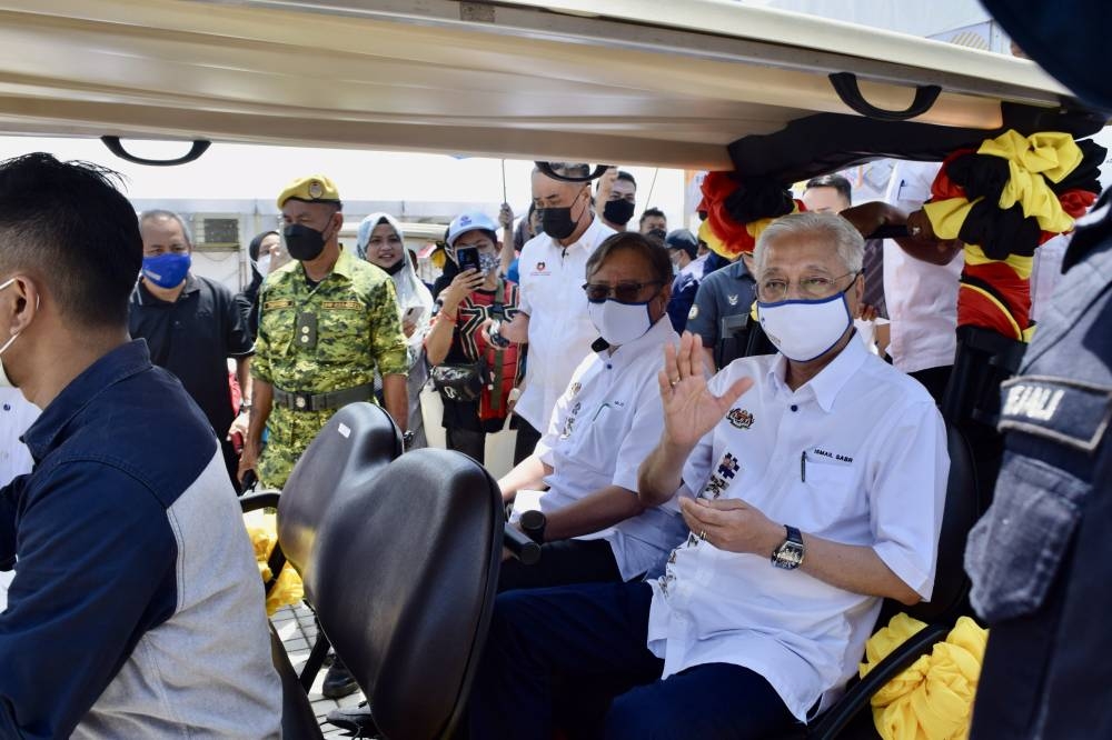 Ismail Sabri, with Abang Johari on his right, waves to the crowd as they are being transported via buggy to the main stage for the closing ceremony of ‘Jelayah Aspirasi Keluarga Malaysia’ programme in Petra Jaya. —  Borneo Post Online pic