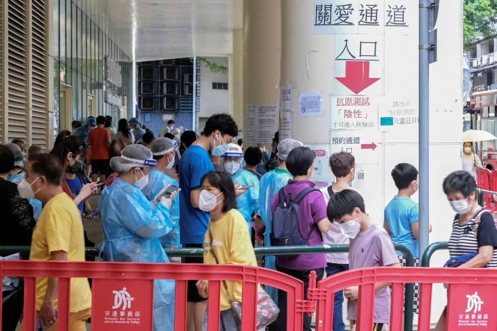 Residents wearing face masks line up to get tested for Covid-19 in Macau, China July 4, 2022. — Reuters pic