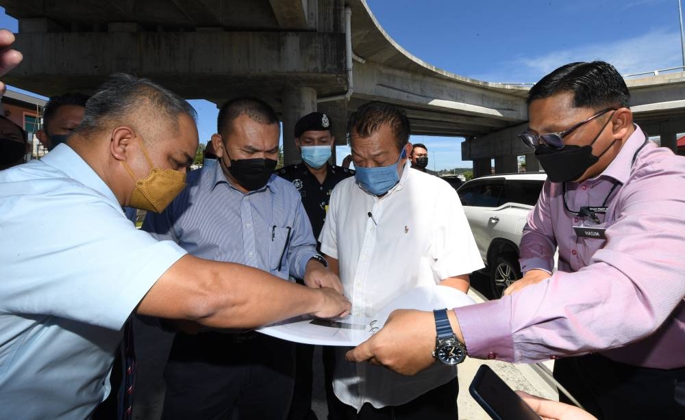 Sabah Deputy Chief Minister Datuk Seri Bung Moktar Radin being briefed during his visit to the new stretch of road at Lintas, August 8, 2022. — Bernama pic 