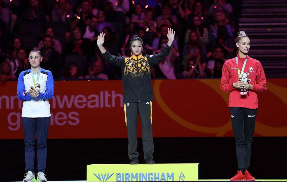 National gymnast Ng Joe Ee (centre) celebrates winning gold at the Rhythmic gymnastics 'Ribbon' event at the 2022 Commonwealth Games in Birmingham August 6, 2022. — Bernama pic  