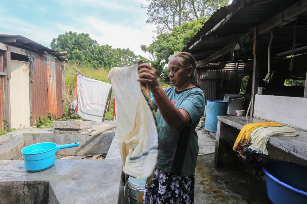 Susileea handwashes the items brought in to the family's launderette. — Picture by Farhan Najib