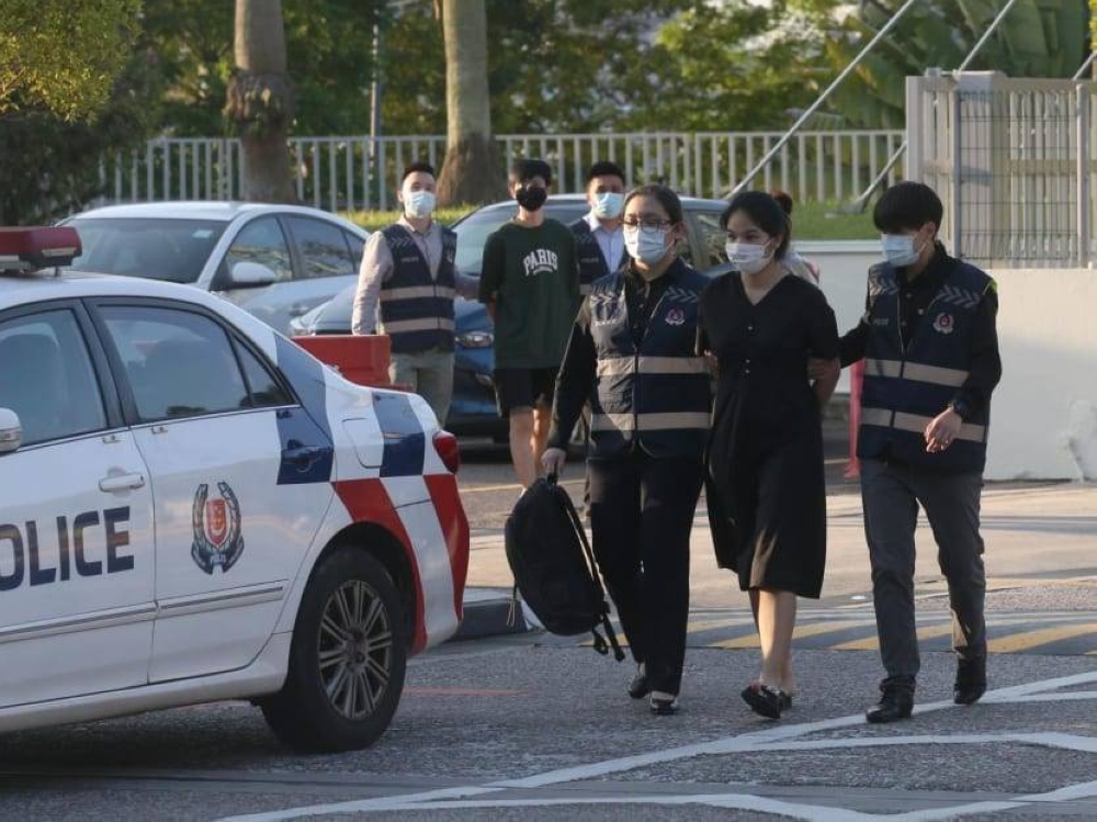 Singaporean Pi Jiapeng, 26, and his 27-year-old Thai wife Pansuk Siriwip are seen being apprehended by Singapore police. — TODAY pic