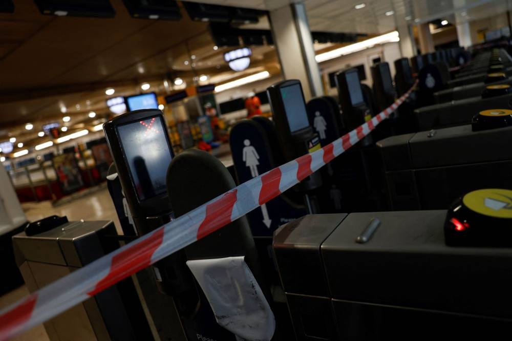 A photograph taken on August 3, 2022 shows closed trains ticket barriers at Charing Cross train station in London, as a fresh railway strikes hit the country. — AFP pic