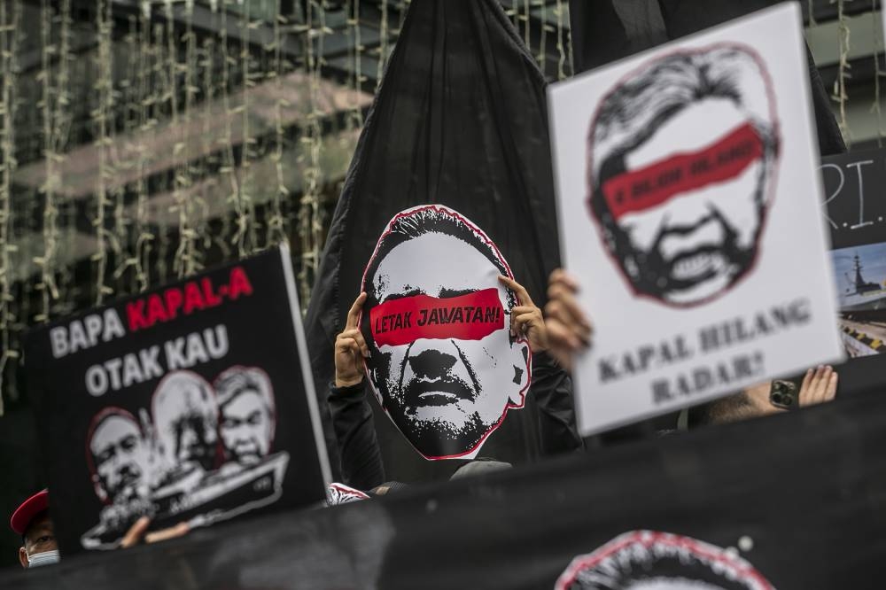 Protesters hold placards during the ‘Where are the Littoral Combat Ships (LCS)?’ protest gathering in front of a shopping complex in Jalan Tuanku Abdul Rahman, August 14, 2022. —  Picture by Hari Anggara