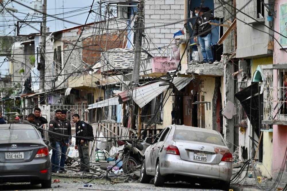 Members of the National Police inspect the site of an explosion, which the Ecuadorean government attributes to organized crime, in southern Guayaquil, Ecuador, on August 14, 2022. — AFP pic