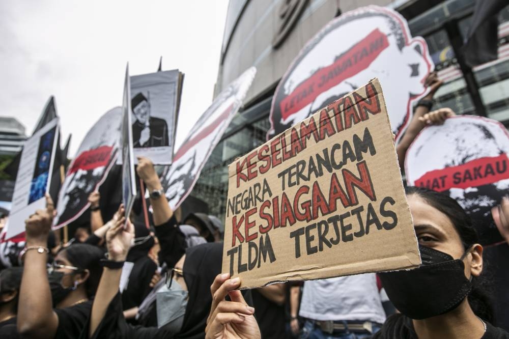 A protester holds a placard during the LCS gathering in Kuala Lumpur, August 14, 2022. — Picture by Hari Anggara