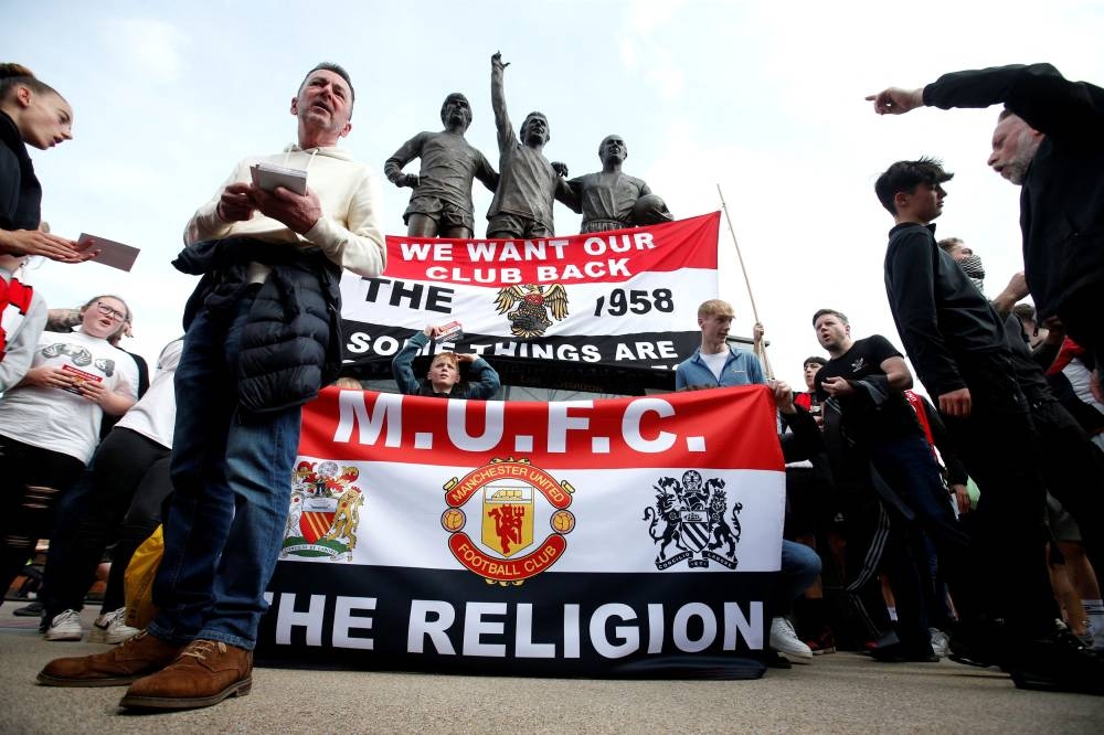 Manchester United fans display banners in protest of the Glazer family’s ownership of the club outside the stadium before the match at Old Trafford, Manchester, Britain, April 16, 2022. — Action Images pic via Reuters