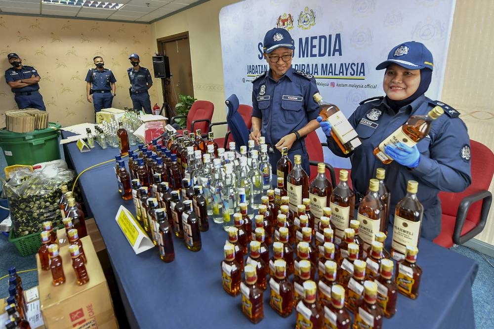 Customs director-general Datuk Zazuli Johan (2nd, right) and his officers show bottles containing alcohol seized by the Royal Malaysian Customs Department Central Zone Unit III at the KLIA Customs Complex, August 18, 2022.— Bernama pic 