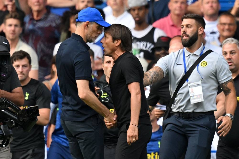 Tottenham Hotspur's Italian head coach Antonio Conte and Chelsea's German head coach Thomas Tuchel shake hands then clash after the English Premier League football match between Chelsea and Tottenham Hotspur at Stamford Bridge in London on August 14, 2022. — AFP pic