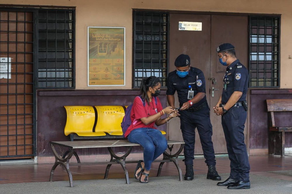Keretapi Tanah Melayu Berhad auxiliary police conducting a check on KTM Komuter passenger in Shah Alam, Selangor during the June 2021 movement control order. — Picture by Yusof Mat Isa