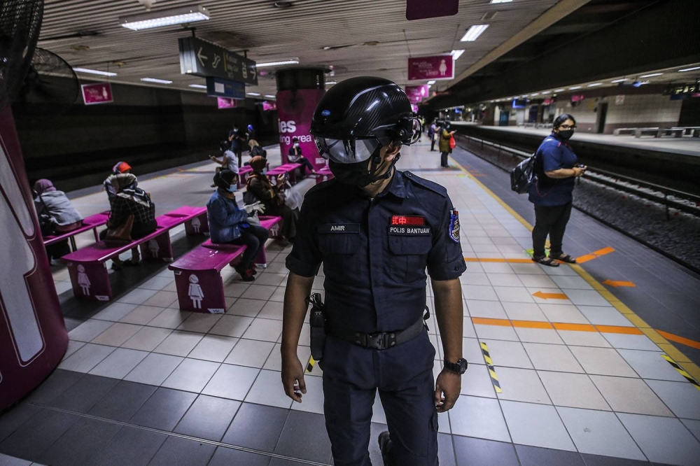 A general picture of the KTMB auxiliary police wearing the temperature scanner helmets patrols its station and trains during the CMCO in KL Sentral. — Picture by Hari Anggara.