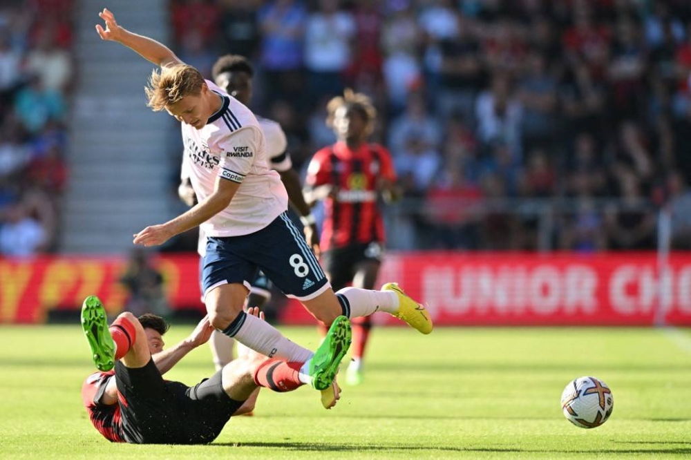 Bournemouth's Welsh striker Kieffer Moore (left) fights for the ball with Arsenal's Norwegian midfielder Martin Odegaard during the English Premier League match between Bournemouth and Arsenal at the Vitality Stadium in Bournemouth, southern England on August 20, 2022. — AFP pic