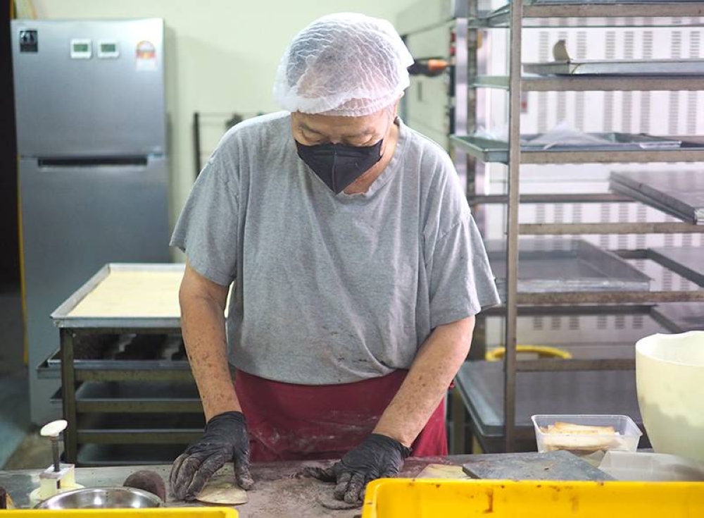 Goh slowly makes the mooncakes, rolling out the dough and pressing it out by hand.