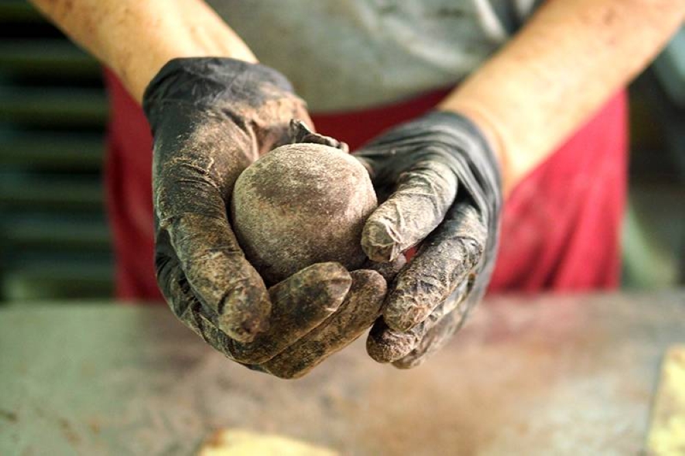It takes skilled hands to get smooth dough covering the filling for the chocolate mooncakes.