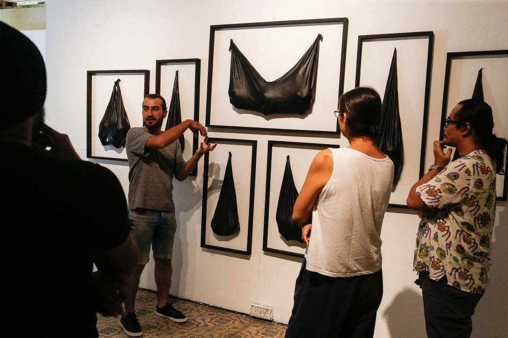 Aboud Fares explaining his artwork called 'Bagged' at the Tu7oh Exhibition at Hin Bus Depot in Georgetown July 6, 2022. — Picture by Sayuti Zainudin