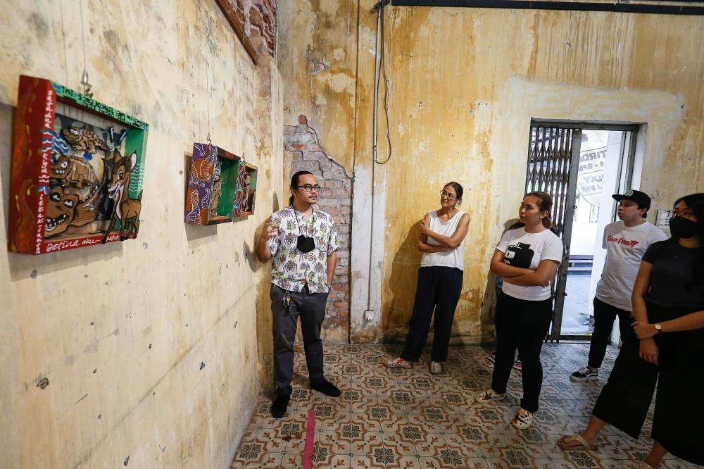 Maizul Affendy pictured explaining his artwork called 'Mula Semula Vol 2' at the Tu7oh Exhibition at Hin Bus Depot in Georgetown July 6, 2022. — Picture by Sayuti Zainudin