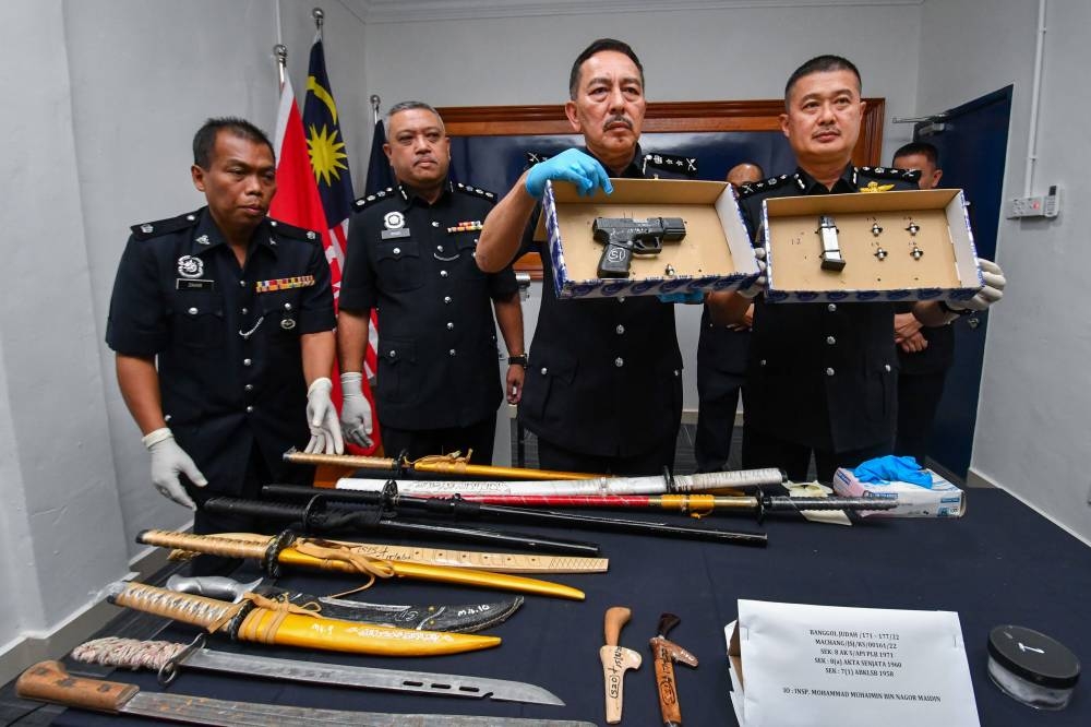 Acting Kelantan police chief Datuk Muhamad Zaki Harun with the seized weapons in Kota Baru, August 22, 2022. — Bernama pic 
