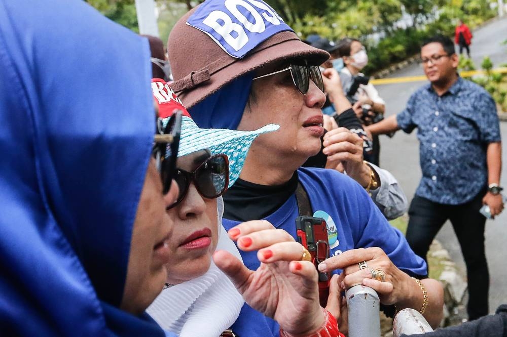Supporters shed tears after hearing the verdict of former prime minister Datuk Seri Najib Razak at the Palace of Justice in Putrajaya August 23, 2022. — Picture by Sayuti Zainudin